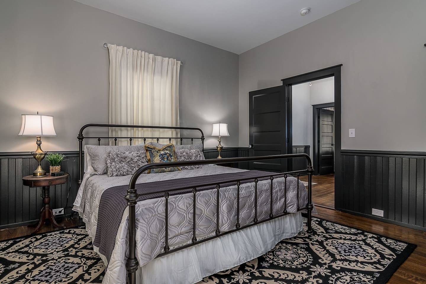 King bedroom with black metal bed and historic trim