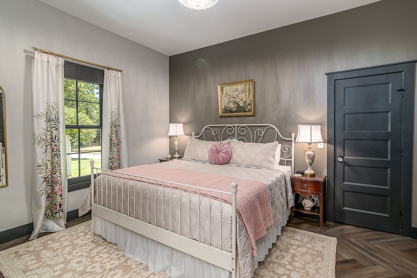 King bedroom with blush bedding and white metal bed